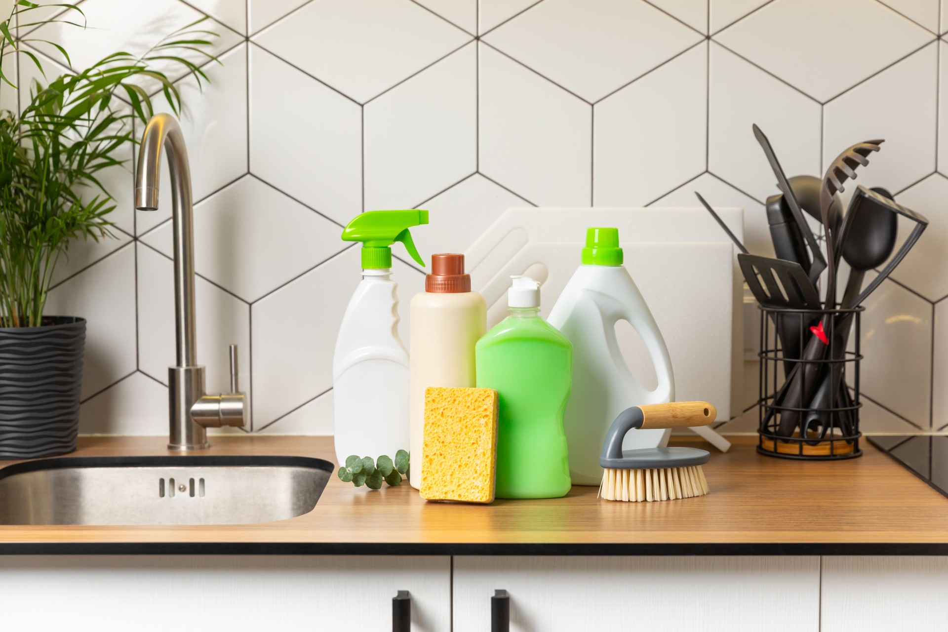 Eco cleaning products against the background of the kitchen. Eco-friendly home cleaning. A bottle of natural detergent surfaces, eco brushes, sponges, and rags. Cleaner concept.Cleaning supplies.